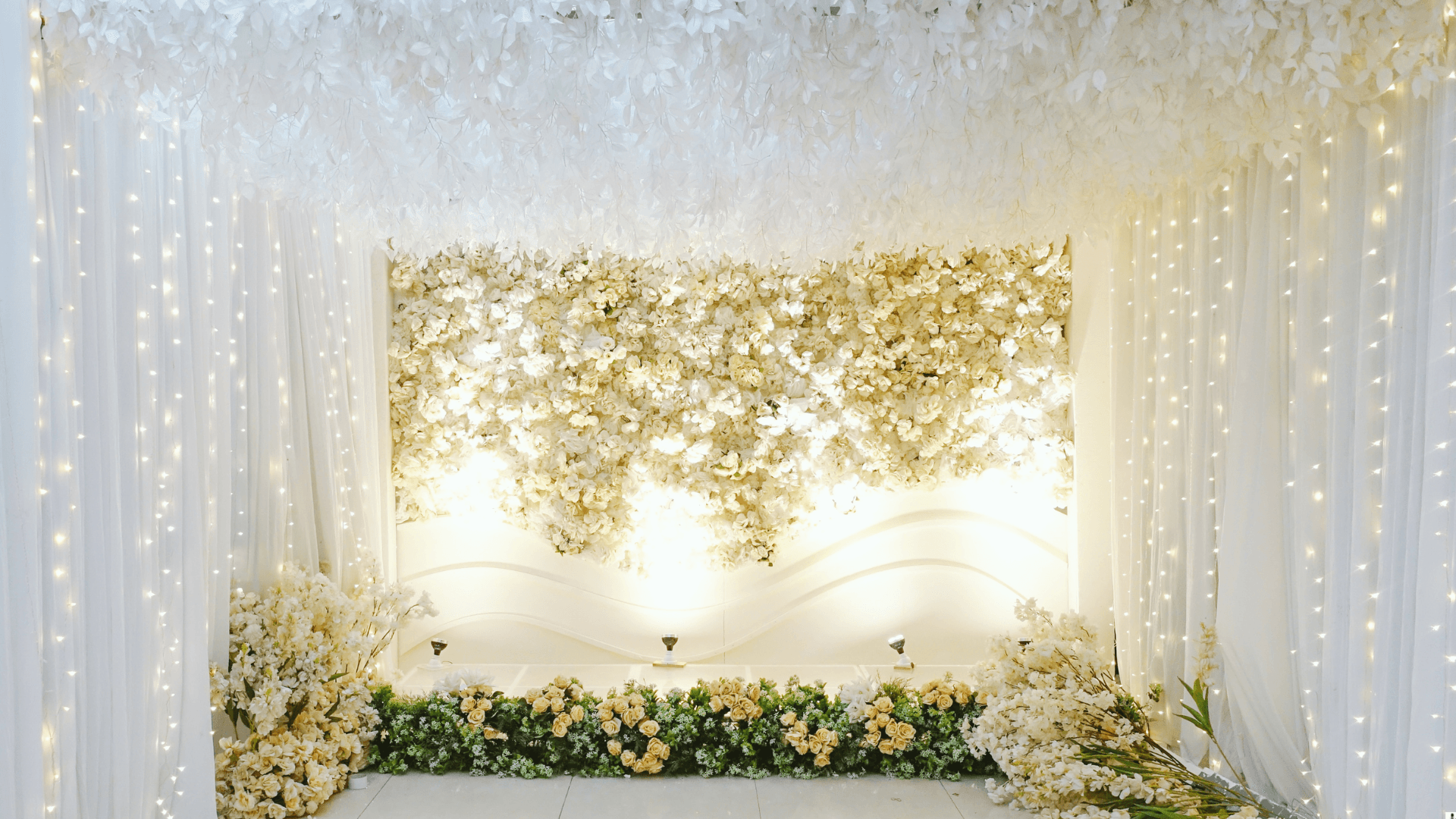 White floral wall backdrop with fairy lights