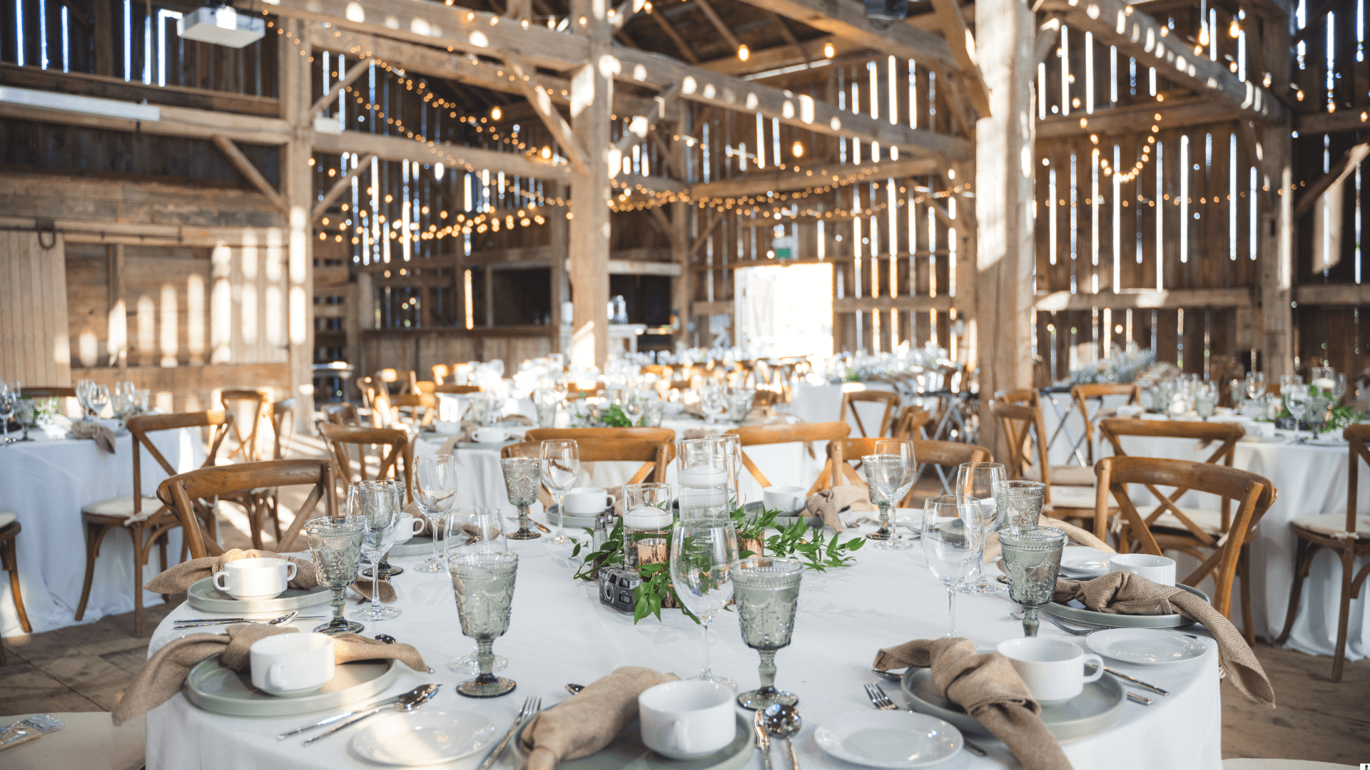 Rustic barn dinner with fairy lights and round tables
