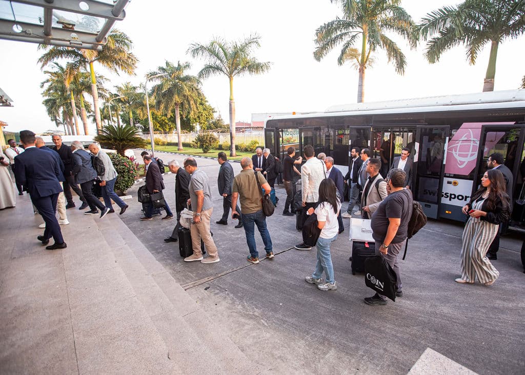 Delegation disembarking a VIP shuttle bus with luggage at the airport