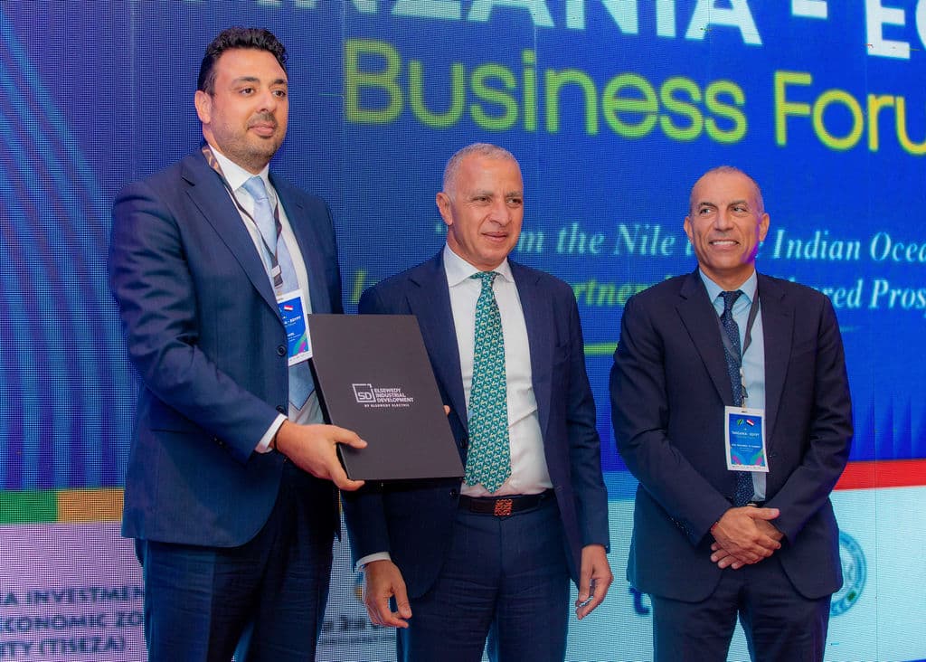 Executives exchanging a plaque during a presentation ceremony on stage
