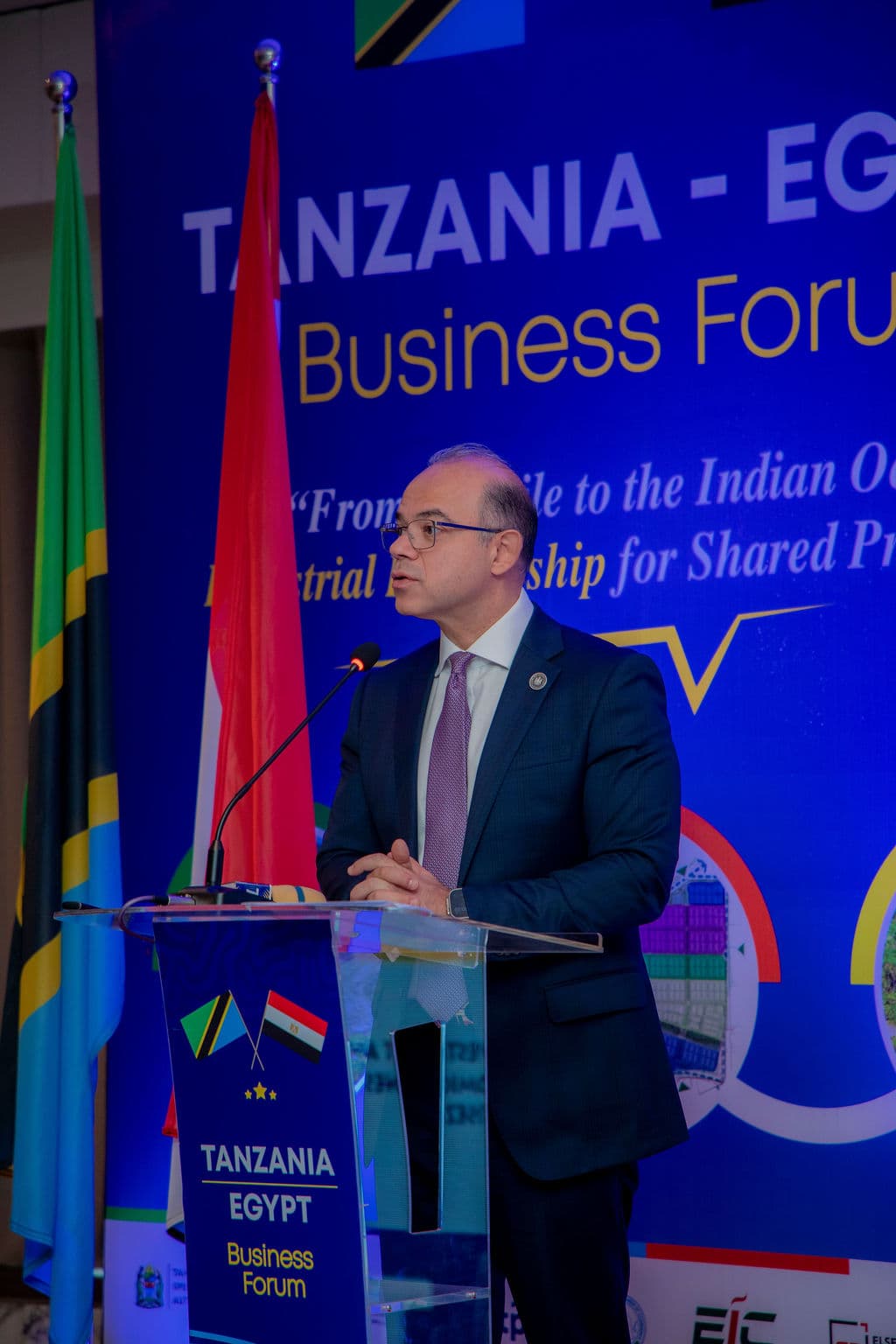 Speaker gesturing while addressing delegates from the forum podium