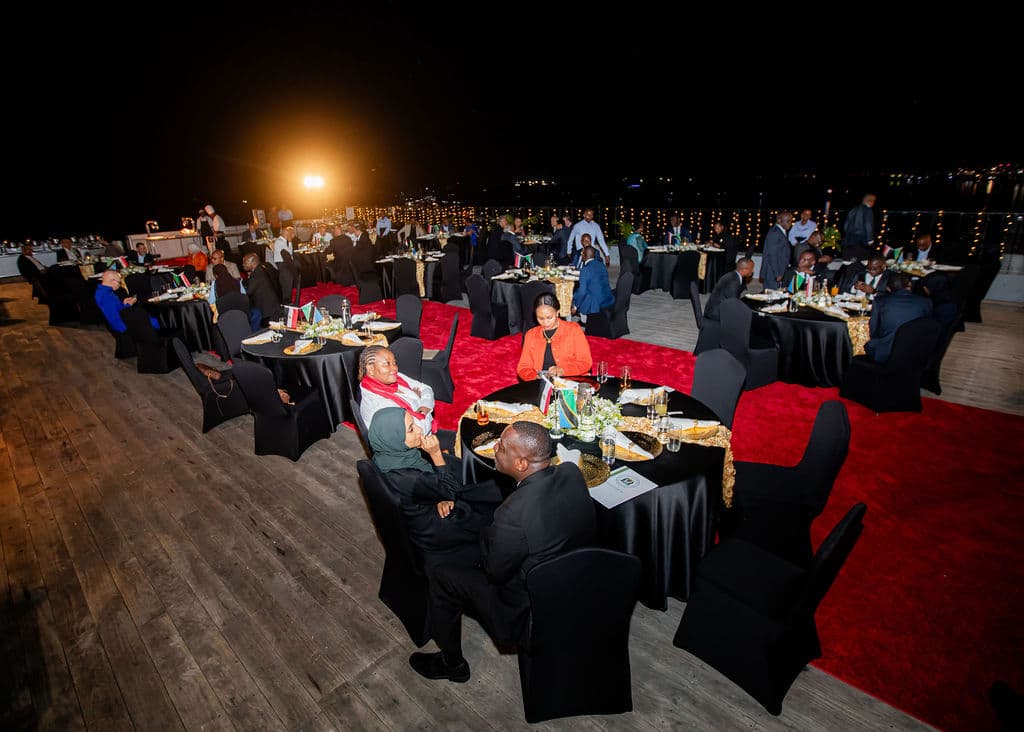 Wide view of the rooftop gala dinner setup with string lights and red carpet at night