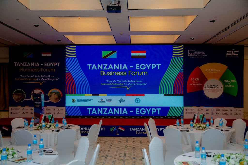 Large LED screen branded with the Tanzania-Egypt Business Forum logo above set banquet tables
